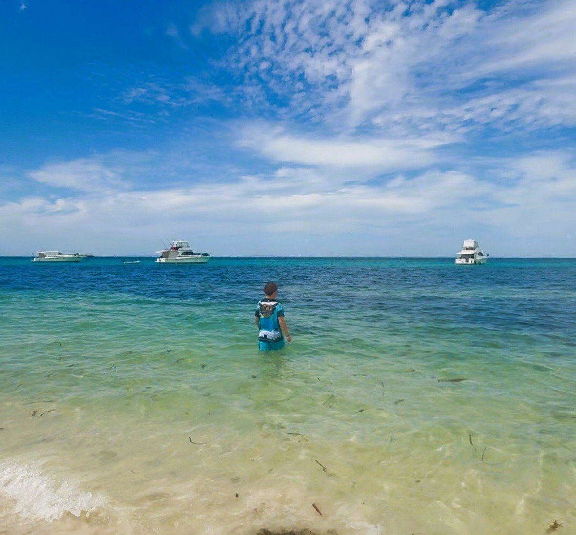 A figure wading into open water — presence and possibility